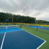 Pickleball court with fence cap protection
