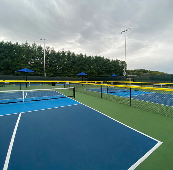 Pickleball court with fence cap protection