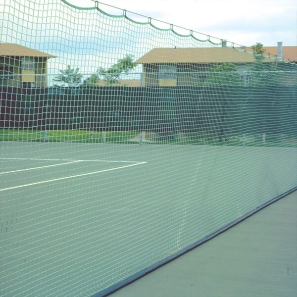 23955Z-2 | National Sports Products Tennis court enclosed by a green mesh fence, with a long net and white lines on the court; houses in the background under a cloudy sky.
